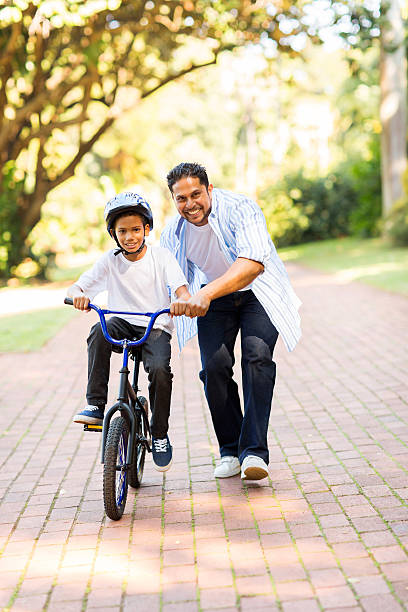 istock indian father teaching his son to ride a bicycle 527863921