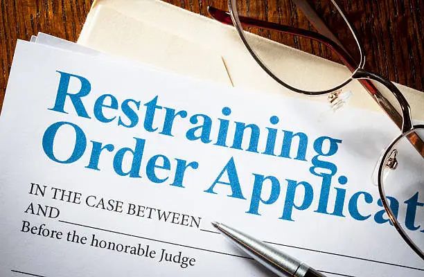Restraining Order application with glasses and pen