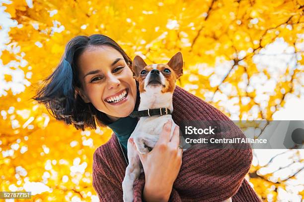 Portrait Of Happy Young Woman With Dog Outdoors In Autumn Stock Photo - Download Image Now