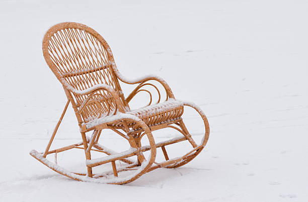 Empty wicker rocking-chair on the fresh snow waiting for master