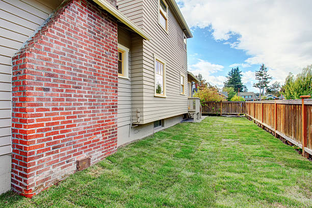 istock House with brick chimney and fenced backyard 527877629
