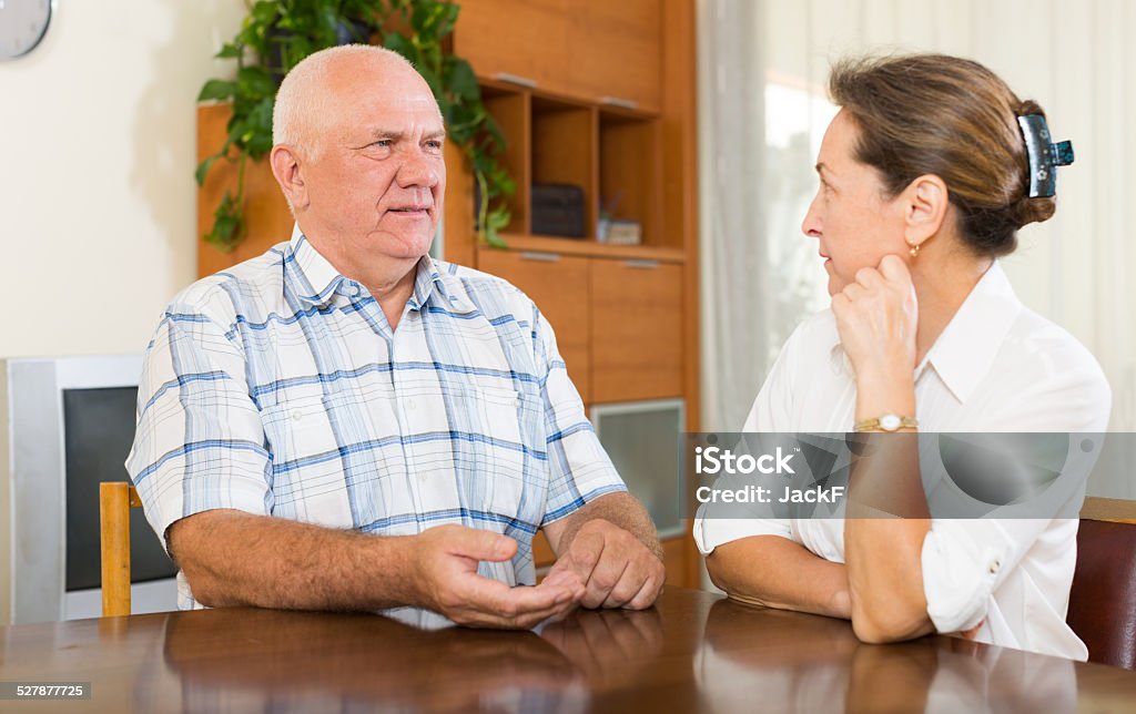 Serious mature couple talking Serious mature couple talking at home. Focus on man 50-59 Years Stock Photo