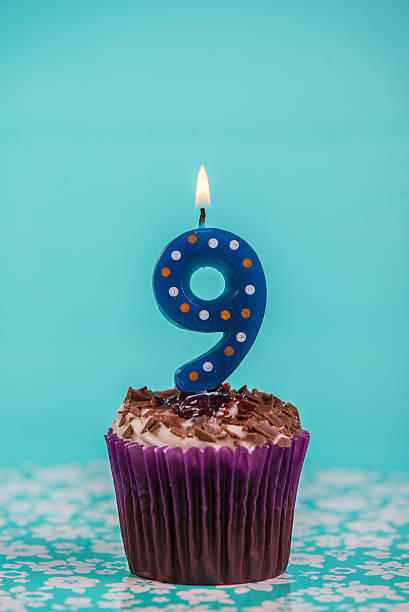 istock birthday cup cake with number nine candle on blue background 527878303