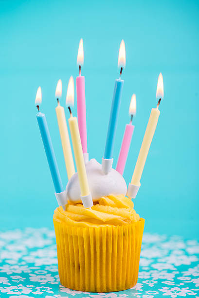 istock birthday cup cake with many candles on blue background 527878307