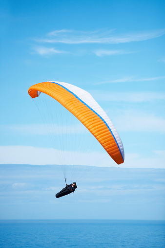 Shot of a man paragliding on a sunny day