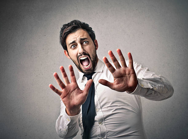 Scared man A man is reacting to something he didn't expect fearfull stock pictures, royalty-free photos & images