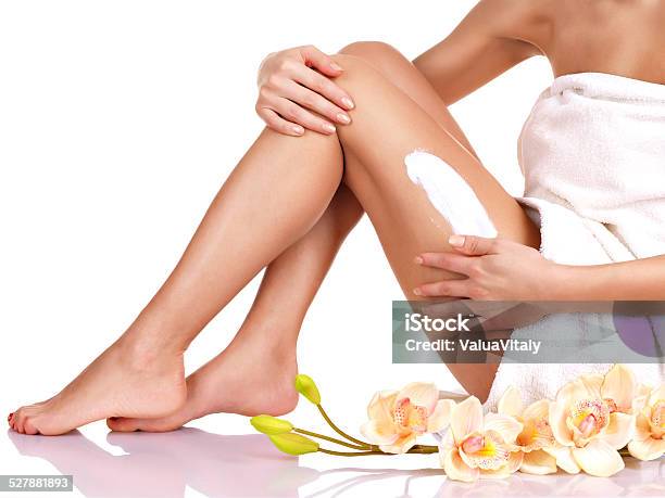 Woman With A Beautiful With Flowers Body Using A Cream Stock Photo - Download Image Now