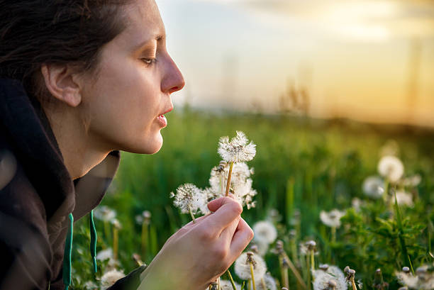 istock beautiful young woman with dandelion 527889370