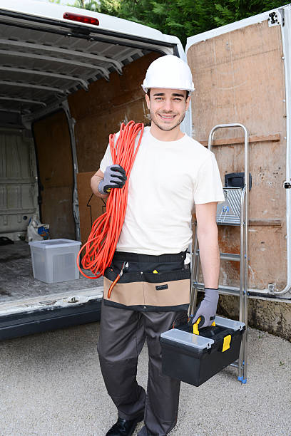 handsome young construction worker with commercial van on background