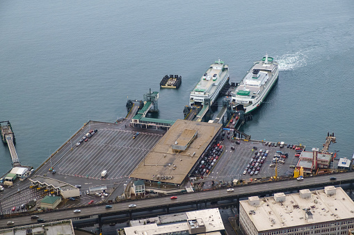 Two Washington State Ferry boats, M/V Kitsap (L) and M/V Wenatchee (R) at the Coleman Dock ferry terminal in Seattle, Washington. The Kitsap has finished loading and will depart for Bremerton, Washington while the Wenatchee continues to load for her sail to Bainbridge Island, Washington.