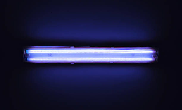 Detail shot of a fluorescent light tube on a wall. Detail shot of a fluorescent light tube on a wall with copyspace. fluorescent stock pictures, royalty-free photos & images