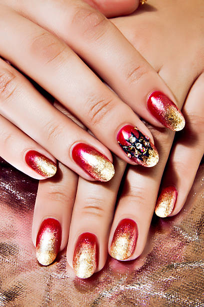 istock Bright Red and Gold Polish on Nails 527894838