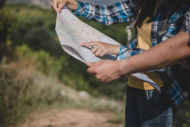istock Young man and woman travelers exploring map 527897172