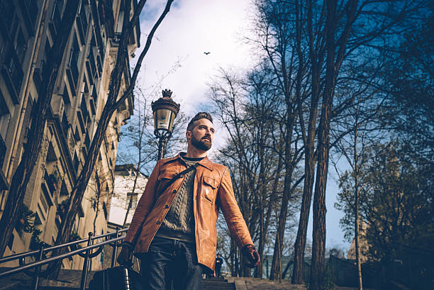 bearded man with suitcase comes down monmartre stairs in paris