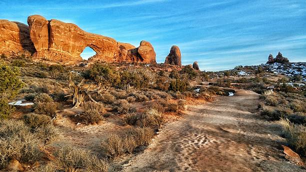 istock Window Arch Formation, Snow, Hiking Trail, Sunset, Arches National Park 527900694
