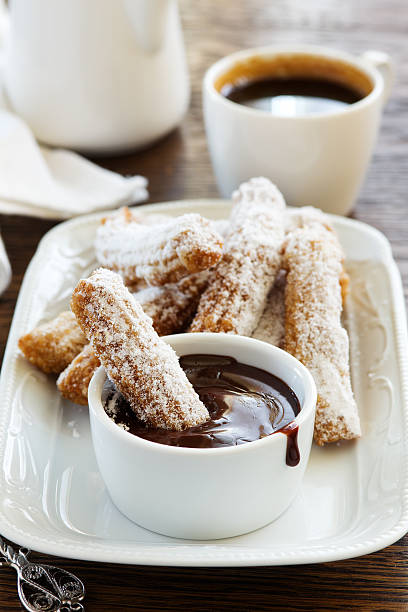 istock Churros with hot chocolate and powdered sugar. 527901386