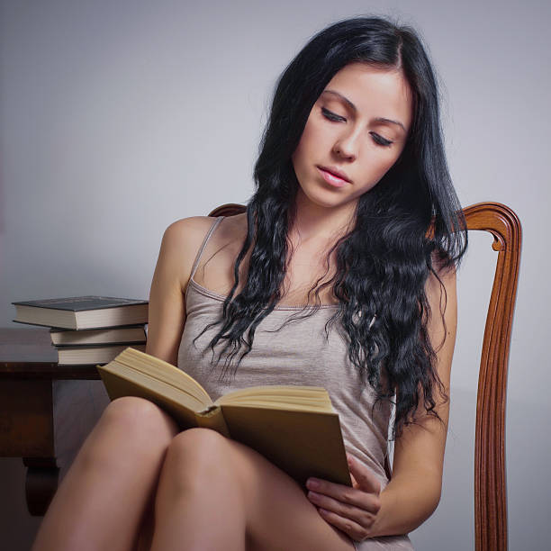 istock Young girl sitting at desk and reading book 527901744