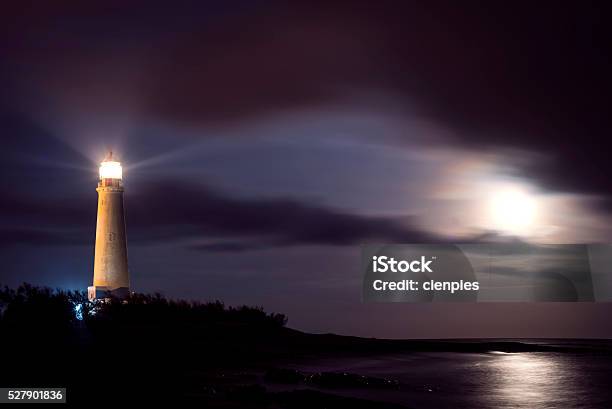 Lighthouse On Beach Coast At Night With Moon Sky Stock Photo - Download Image Now - Lighthouse, Night, Bay of Water