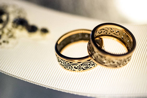 istock Two wedding rings with rare design on white broad ribbon 527901900