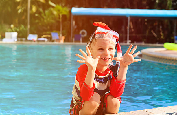 istock happy little boy having fun at pool 527903318
