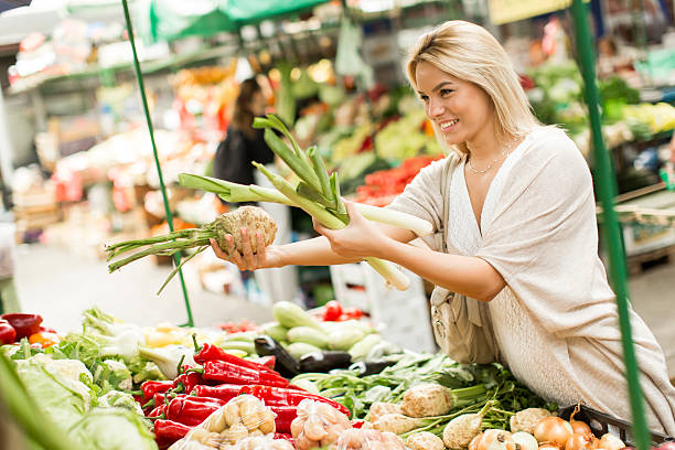 Young woman buying vegetables at the market