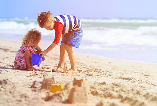 istock kids play with sand on summer beach 527908320