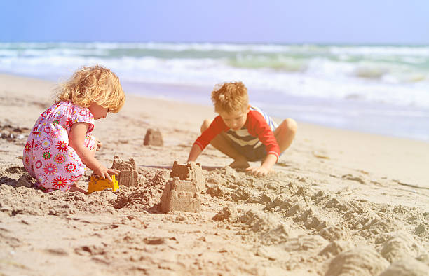istock kids play with sand on summer beach 527908358