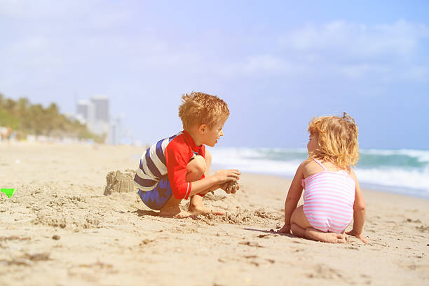 istock kids play with sand on summer beach 527908572