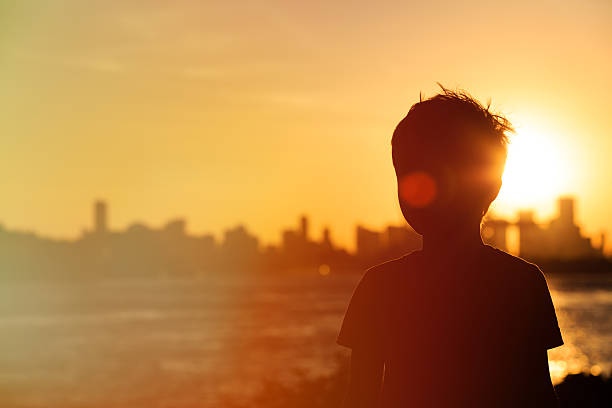 istock little boy looking at sunset city 527908866