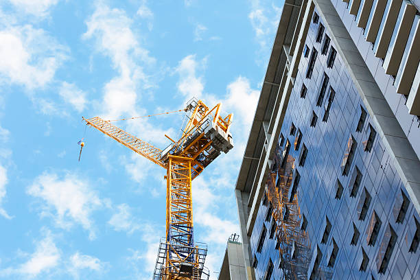 Niedriger Winkelblick auf die Baustelle mit Turmdrehkran gegen blauen Himmel, Sydney Australien, horizontale Vollformatkomposition mit Kopierraum