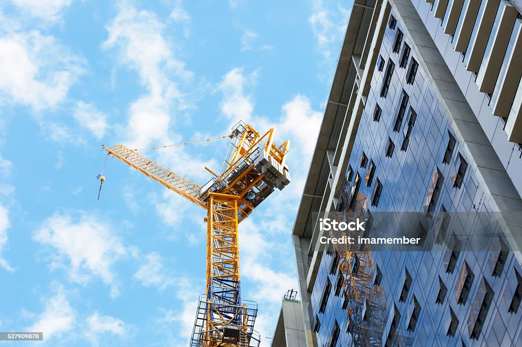 Tower crane at construction site of skyscraper, copy space Low angle view of construction site with tower crane against blue sky, Sydney Australia, full frame horizontal composition with copy space Construction Site Stock Photo