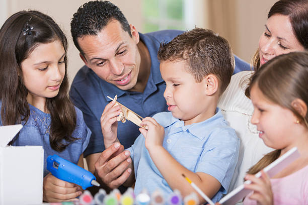 istock Hispanic family, three children doing project together 527910144