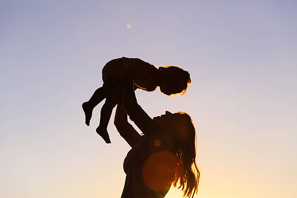 istock mother and little daughter play at sunset 527911700