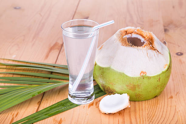 istock Refreshing green coconut fruit juice in glass on wooden table 527911938