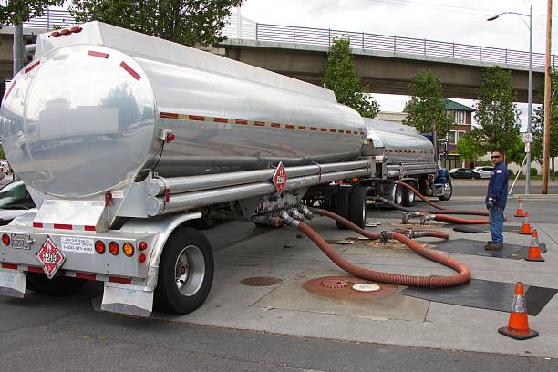 camion americano-tanker si fonde benzina presso un distributore di benzina - fuel tanker foto e immagini stock