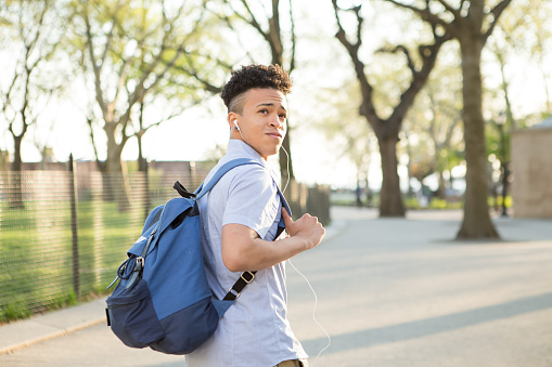 Young educated boy with packpack walk on college campus, photographed in New York City in April 2016.