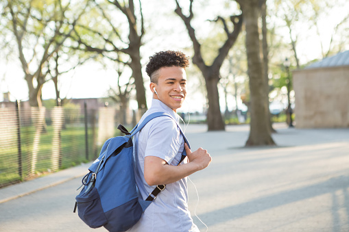 Young educated boy with packpack walk on college campus, photographed in New York City in April 2016.