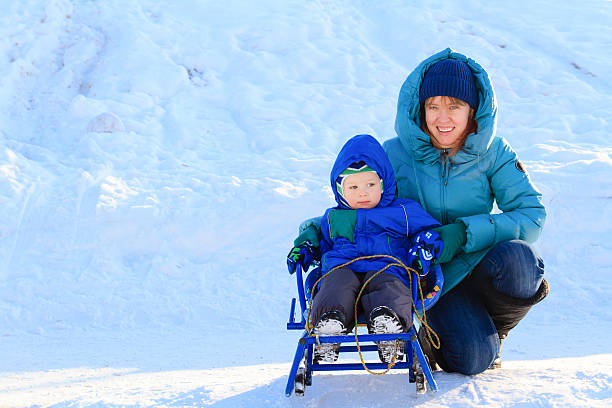 istock mother and son on sledge in winter 527954799