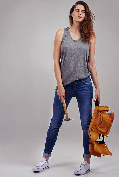 I can fix anything Full length studio portrait of casually-dressed young woman holding a hammer and tool belt woman wearing tool belt stock pictures, royalty-free photos & images