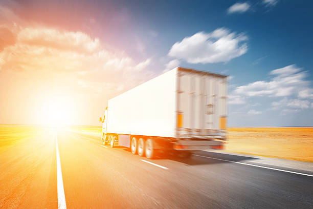 istock semitruck driving to sunset 527955599