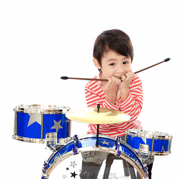 istock Asian young boy playing drum on white background 527956133