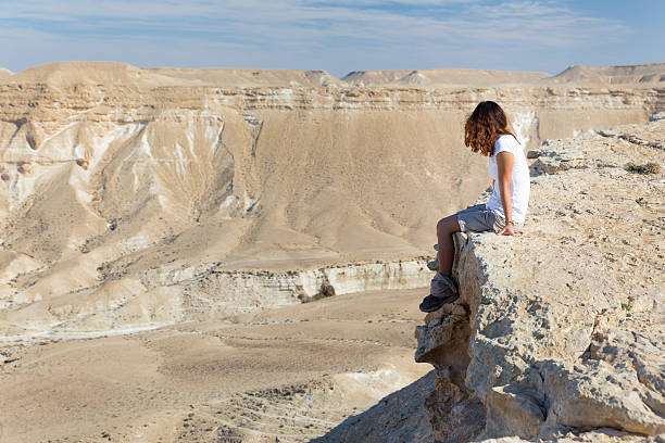 istock Woman sitting desert mountain edge. 527956813