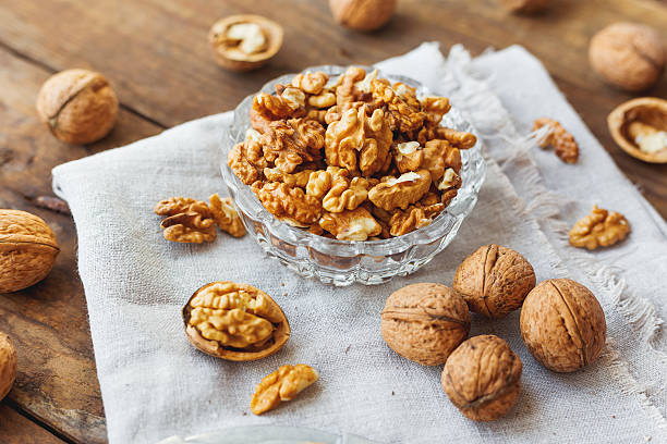 istock Glass bowl with walnuts on rustic homespun napkin. Healthy snack. 528047694