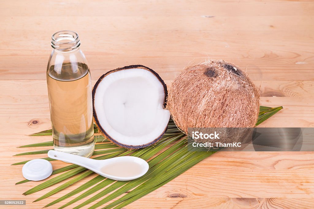 Cold pressed extra virgin coconut oil in bottles with coconuts Cold pressed extra virgin coconut oil in bottles with coconut fruits as background Alternative Therapy Stock Photo