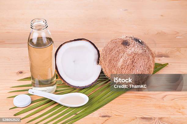 Cold Pressed Extra Virgin Coconut Oil In Bottles With Coconuts Stock Photo - Download Image Now