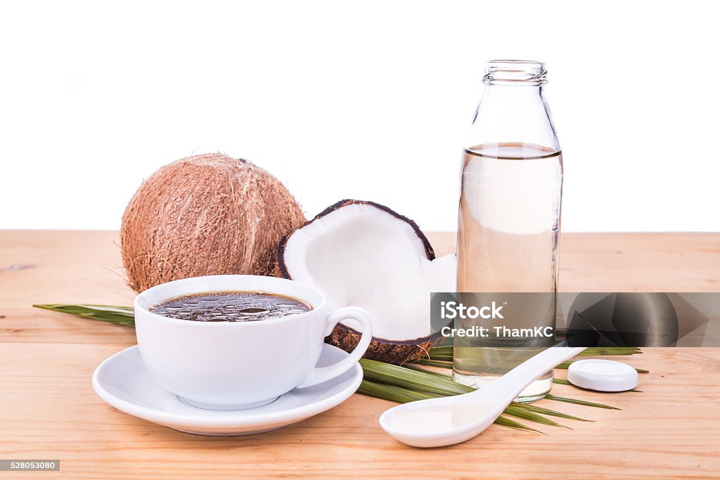 Bulletproof coffee with virgin coconut oil on wooden table Bulletproof coffee with cold pressed extra virgin coconut oil on wooden table, part of ketogenic diet Coconut Stock Photo