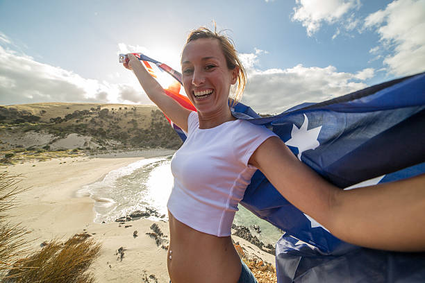 istock Cheering woman on beach holding Australian's flag 528053934