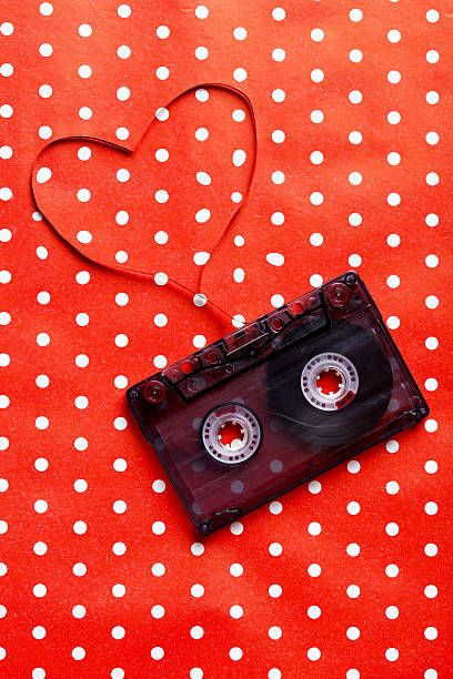 istock Audio tape cassette on red paper background 528054382
