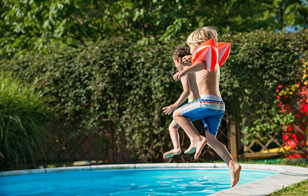 istock Boys Jumping In Swimming Pool 528056242