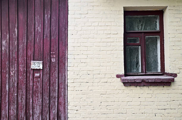 istock Old brick wall with window and fence 528060230